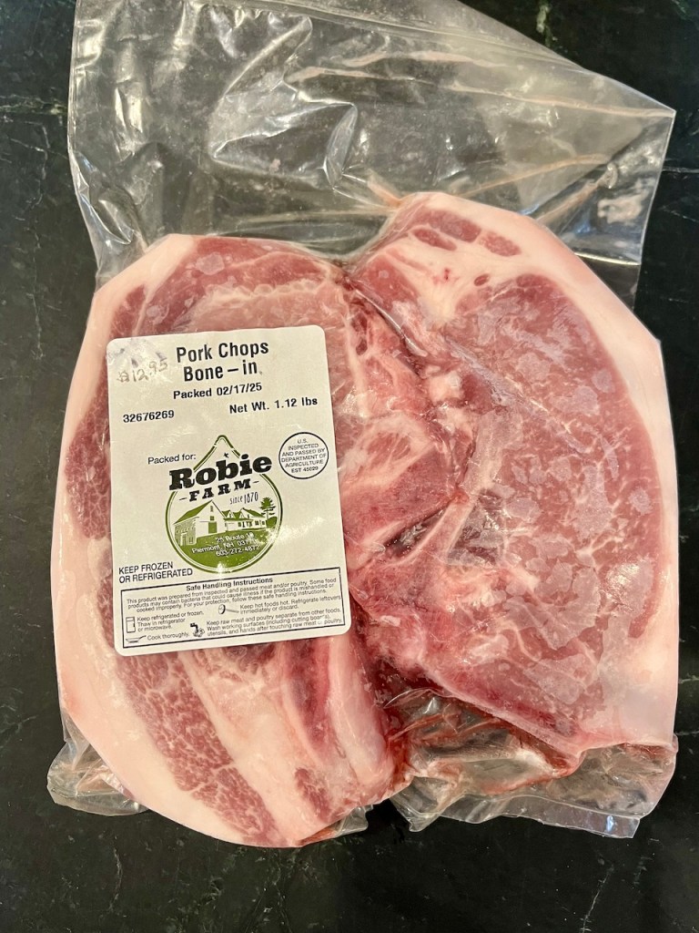Package of bone-in pork chops, labeled with weight and farm information.