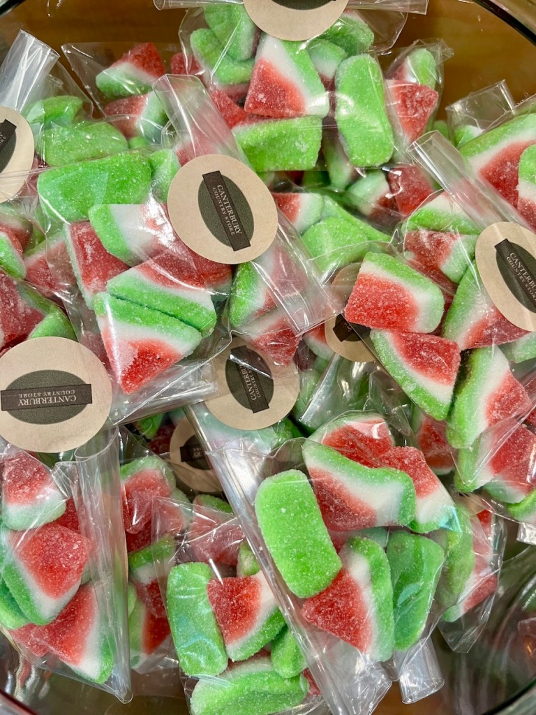 A bowl filled with individually packaged watermelon-flavored candy slices, featuring vibrant green, red, and white colors.