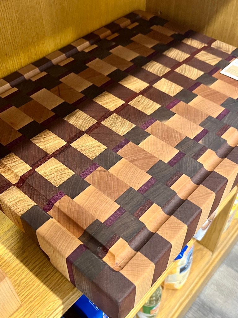 A beautifully crafted wooden cutting board featuring a checkerboard pattern with contrasting shades of light and dark wood.