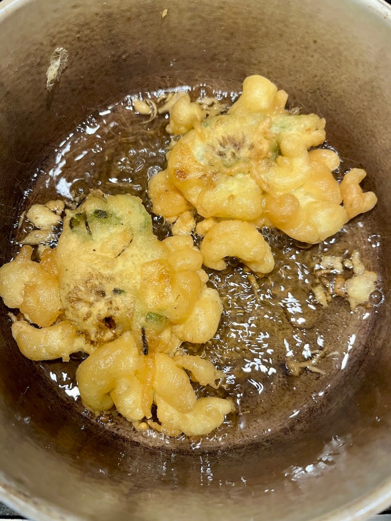Golden-brown crispy fritters frying in oil.