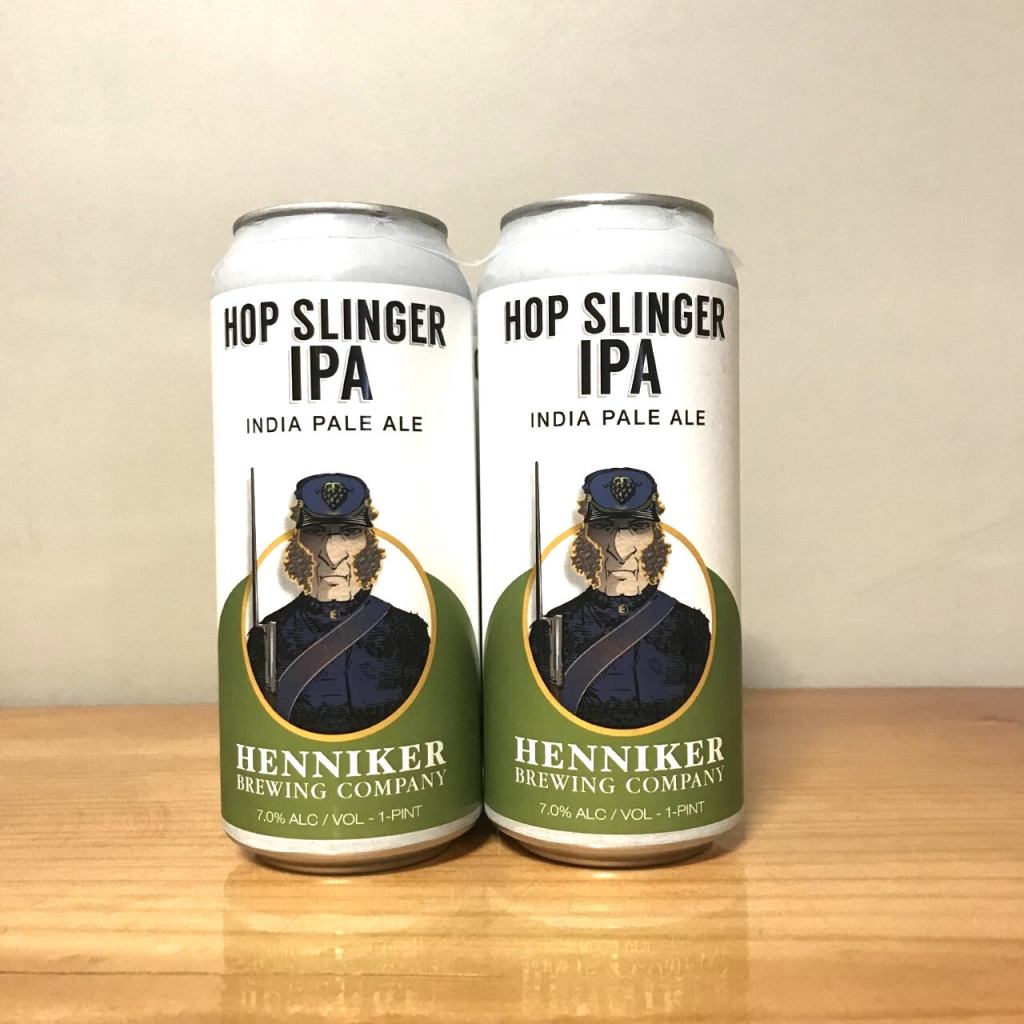 Two cans of Hop Slinger IPA from Henniker Brewing Company, featuring a label with an illustration of a historic figure in a blue uniform.
