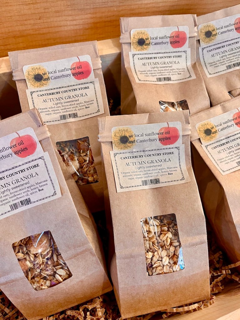 Display of packages containing Autumn granola with labels indicating their ingredients and origin from Canterbury, NH.