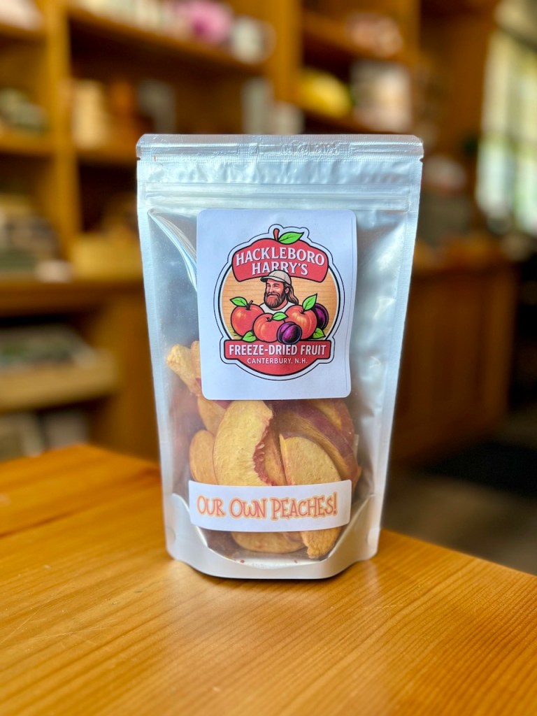 Packaging of freeze-dried peaches from Hackleboro Harry's, displayed on a wooden table with a rustic background.