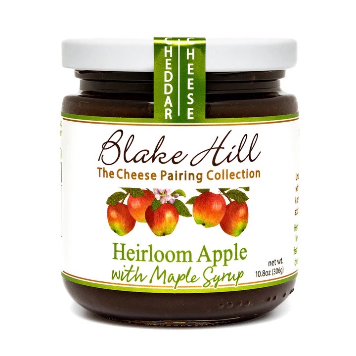 A jar of Blake Hill Heirloom Apple with Maple Syrup, part of The Cheese Pairing Collection, featuring illustrations of apples and a label indicating its weight.