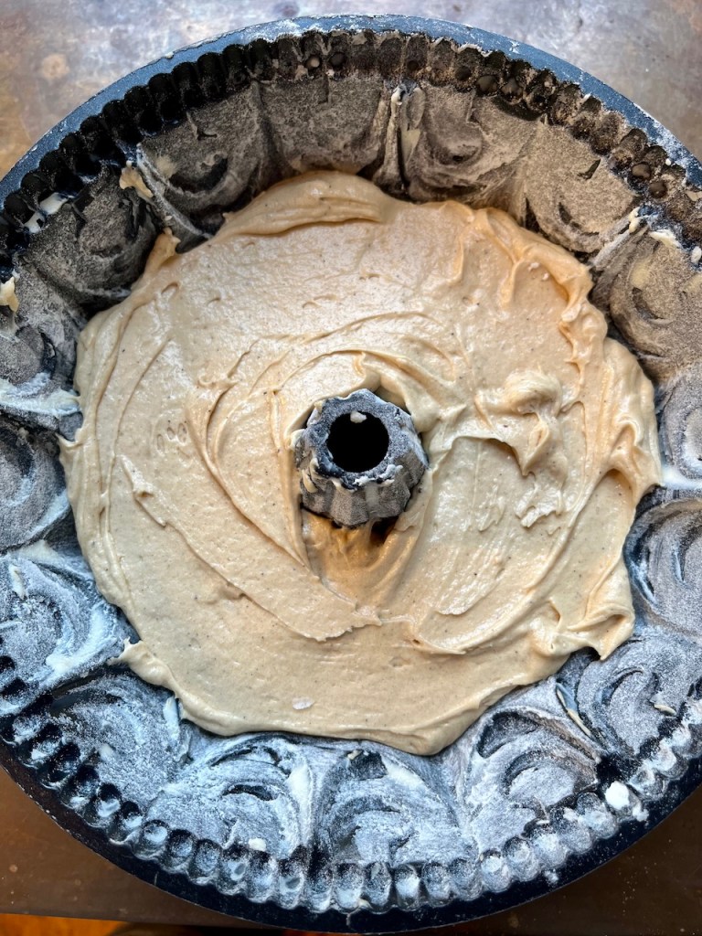 A bundt pan filled with cake batter, ready for baking.