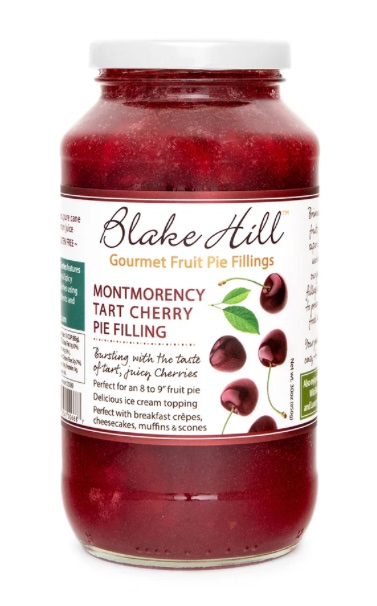 A jar of Blake Hill Gourmet Fruit Pie Fillings featuring Montmorency Tart Cherry Pie Filling. The label highlights the product's features, including its bursting flavor of tart cherries and uses in pies, crepes, and desserts.